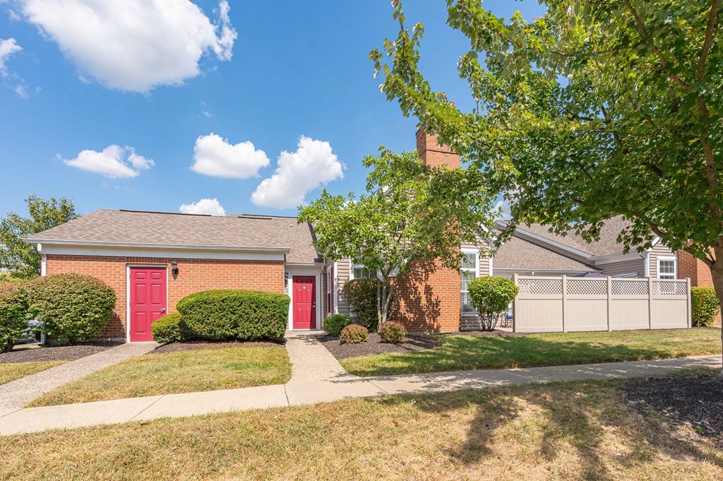 A red garage door is on the left side of a house.