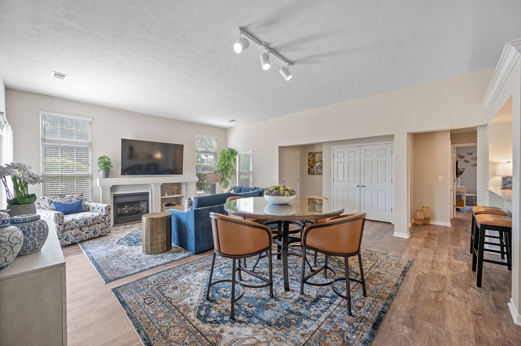 A living room with a fireplace and a dining table.
