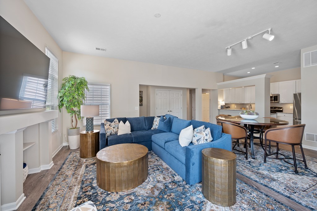 A living room with a blue couch and a fireplace.