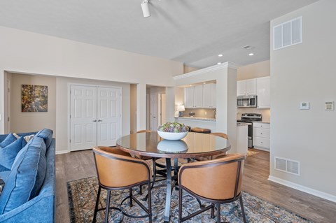 A dining room with a table and chairs.
