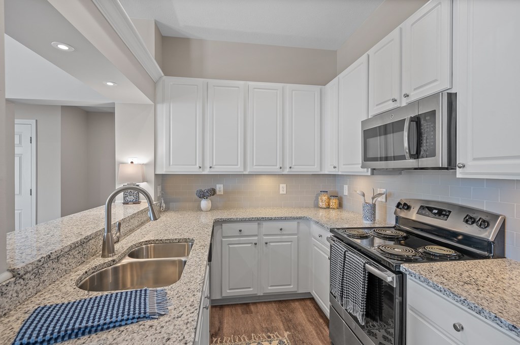 A modern kitchen with a stainless steel oven and microwave.
