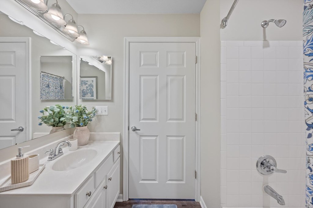 A white bathroom with a white sink and a white door.