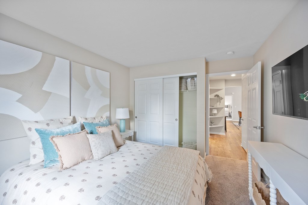 A bedroom with a large bed and a mirror on the wall.