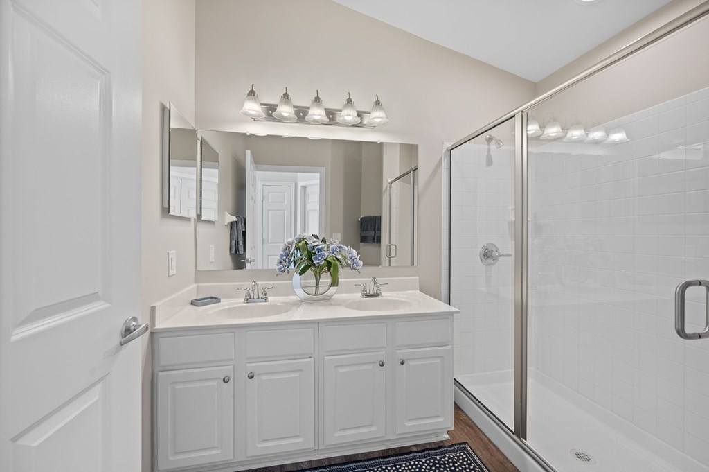 A white bathroom with a sink and mirror.