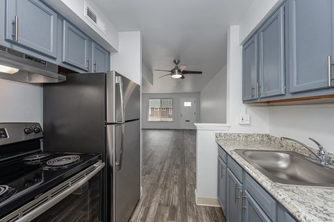 a kitchen with stainless steel appliances and blue cabinets