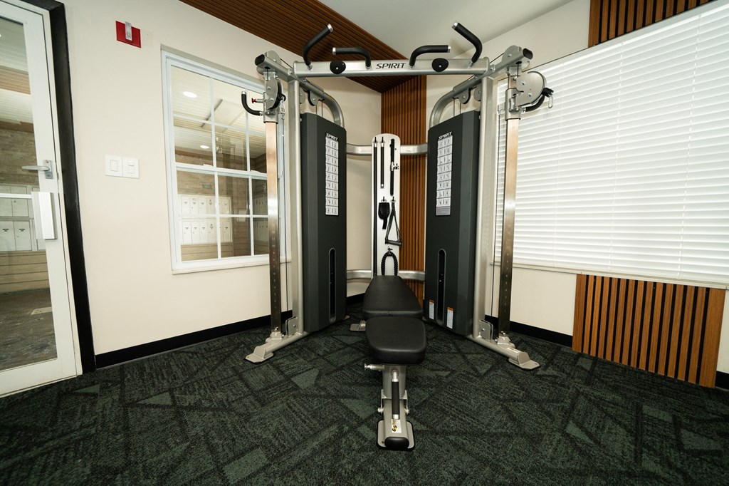 Gym with weights and a chair in the corner of a room at Honey Creek, Greenwood