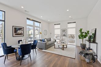 a living and dining room area with white walls and hardwood floors