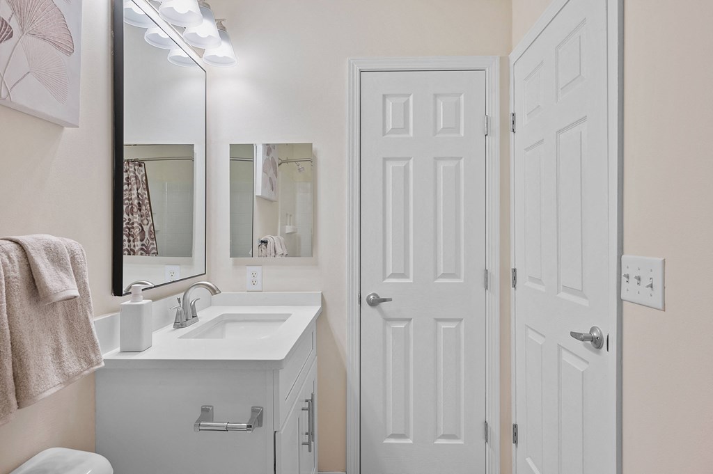 Bathroom with a white sink and a white door at Four Bridges, Liberty Township