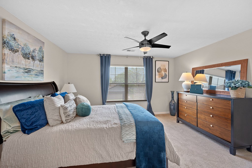 Bedroom with a large bed and a ceiling fan at Four Bridges, Liberty Township