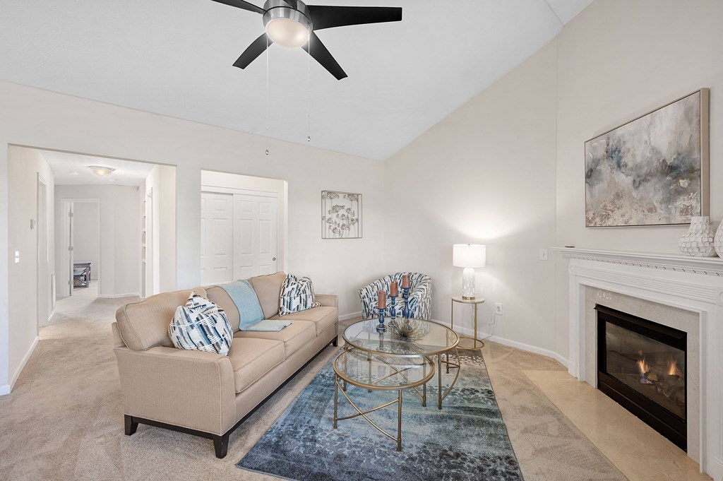 Living room with a couch and a glass coffee table and a fireplace at Four Bridges, Liberty Township, OH, 45044-8380