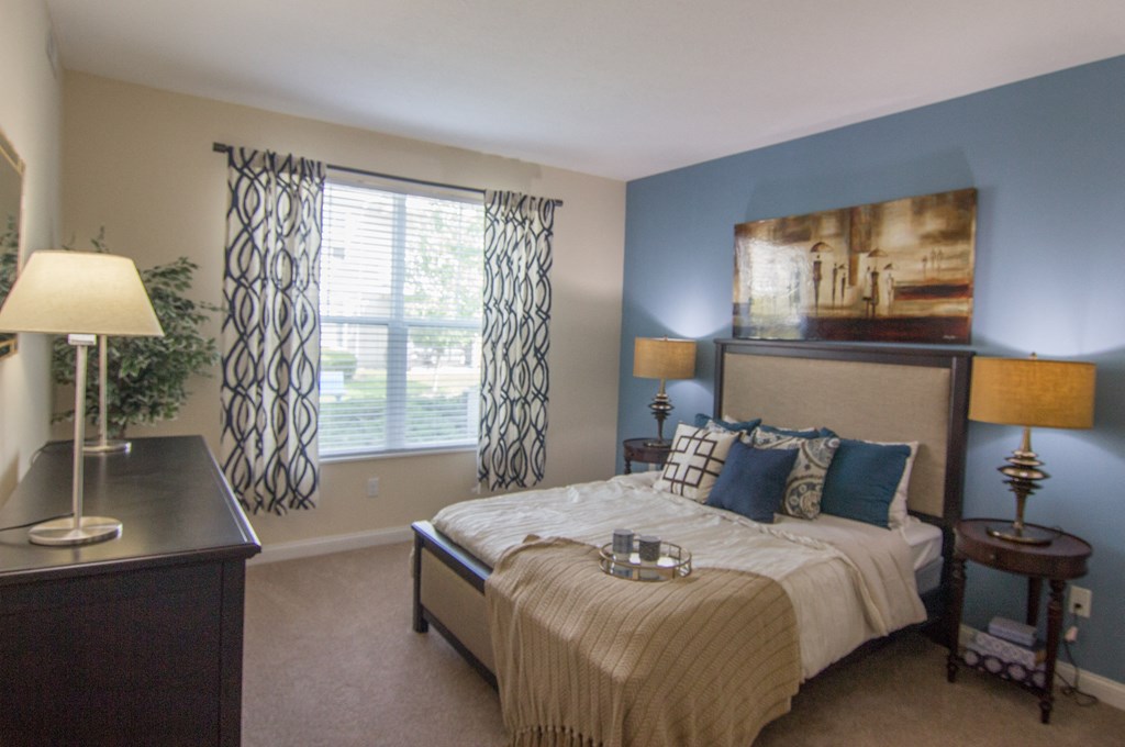 a bedroom with blue walls and a large window  at Grove City Summit, Ohio, 43123