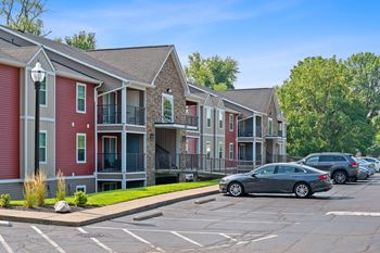 a row of town houses with cars parked in a parking lot