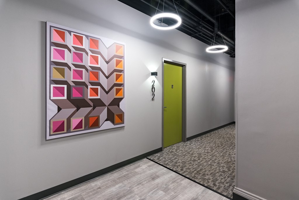 a yellow door in a hallway with a painting on the wall