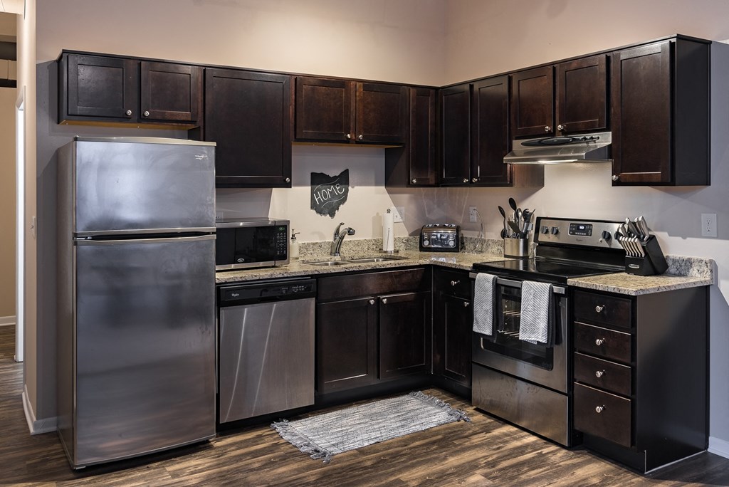 a kitchen with stainless steel appliances and dark wood cabinets