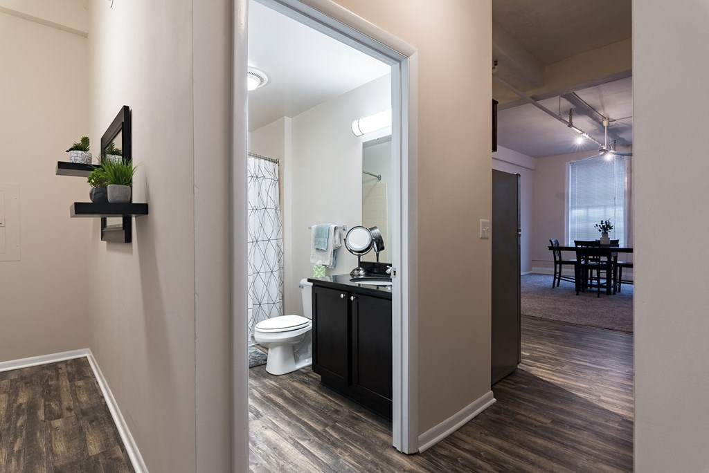 an open doorway into a bathroom with a toilet and a sink