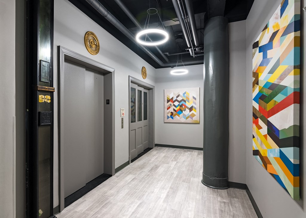 a hallway with two doors and a painting on the wall