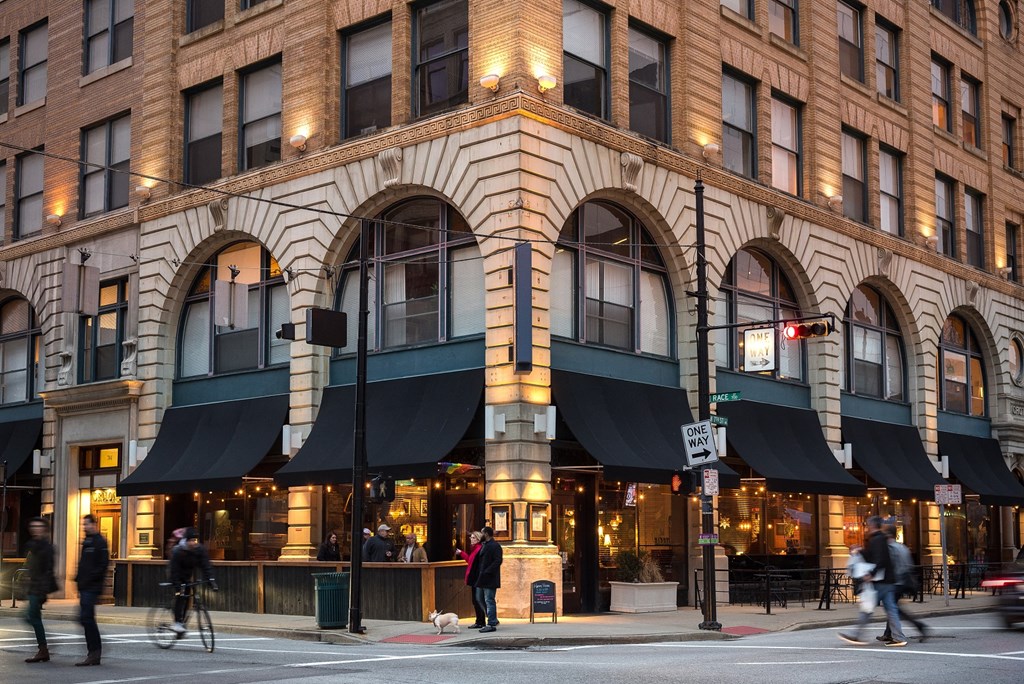 people walking on a city street in front of a building