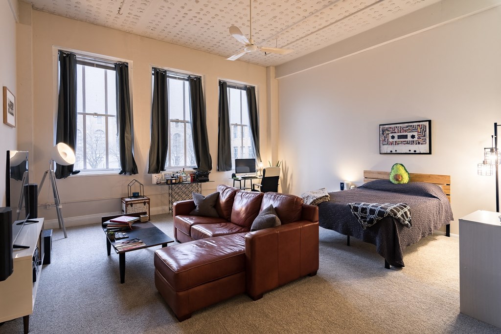 a living room with a couch and a bed in a bedroom
