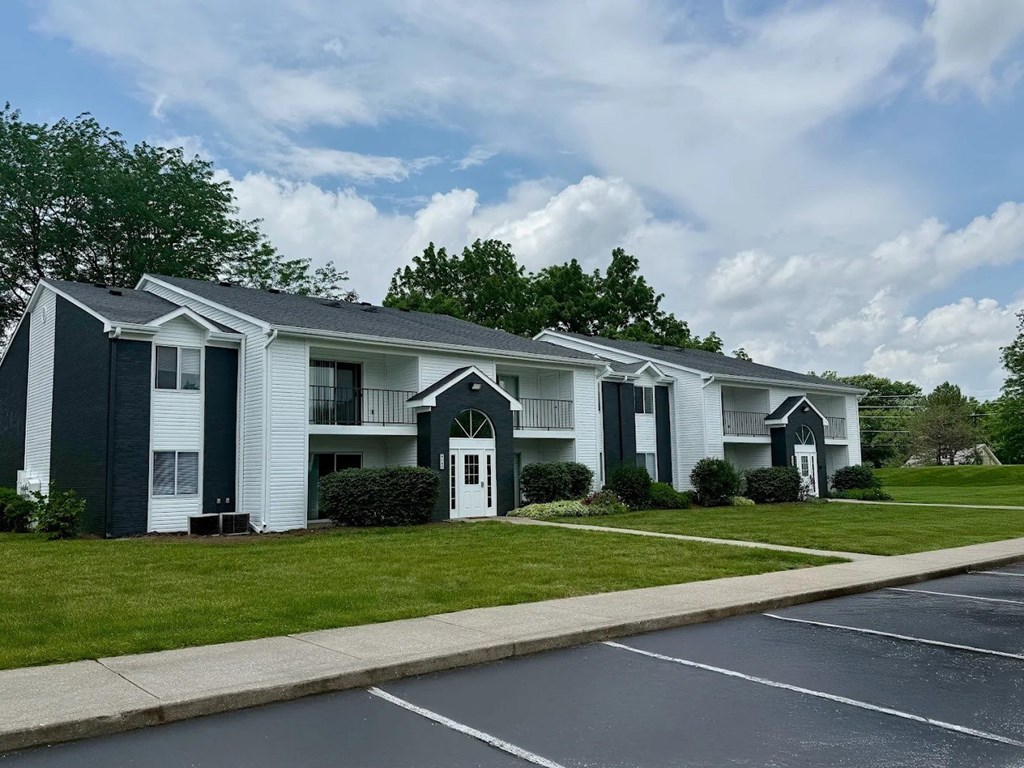 A row of houses with green trim and white siding.