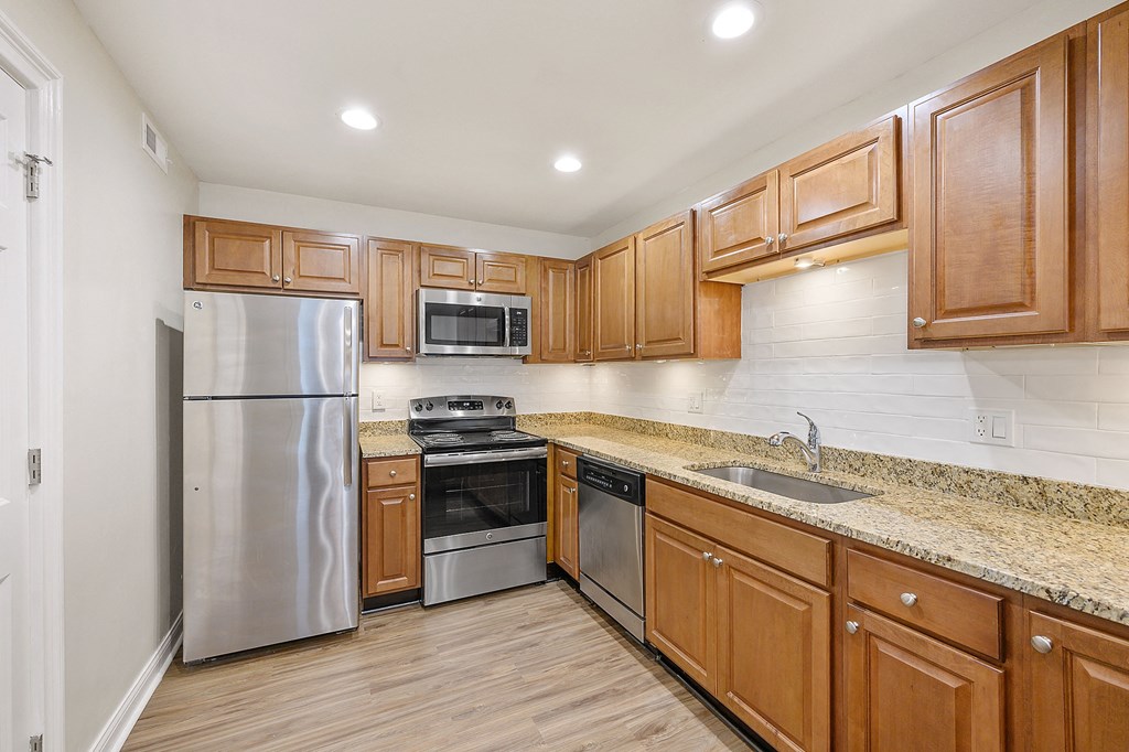 a kitchen with wooden cabinets and stainless steel appliances at Harpers Point Apartments, Cincinnati, OH, 45249