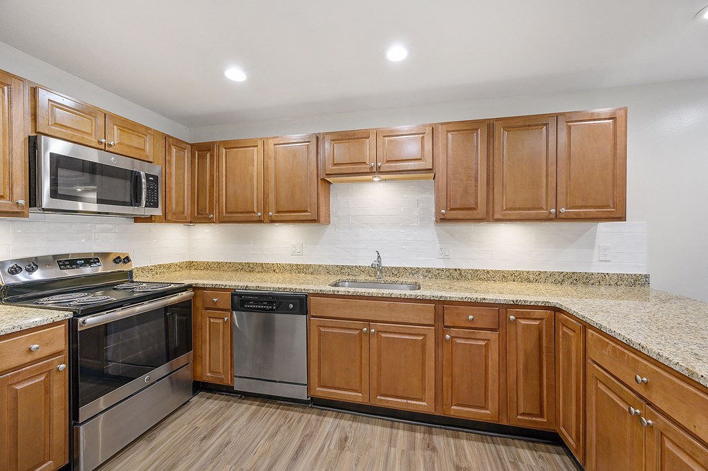 a kitchen with wooden cabinets and granite countertops at Harpers Point Apartments, Cincinnati, OH, 45249