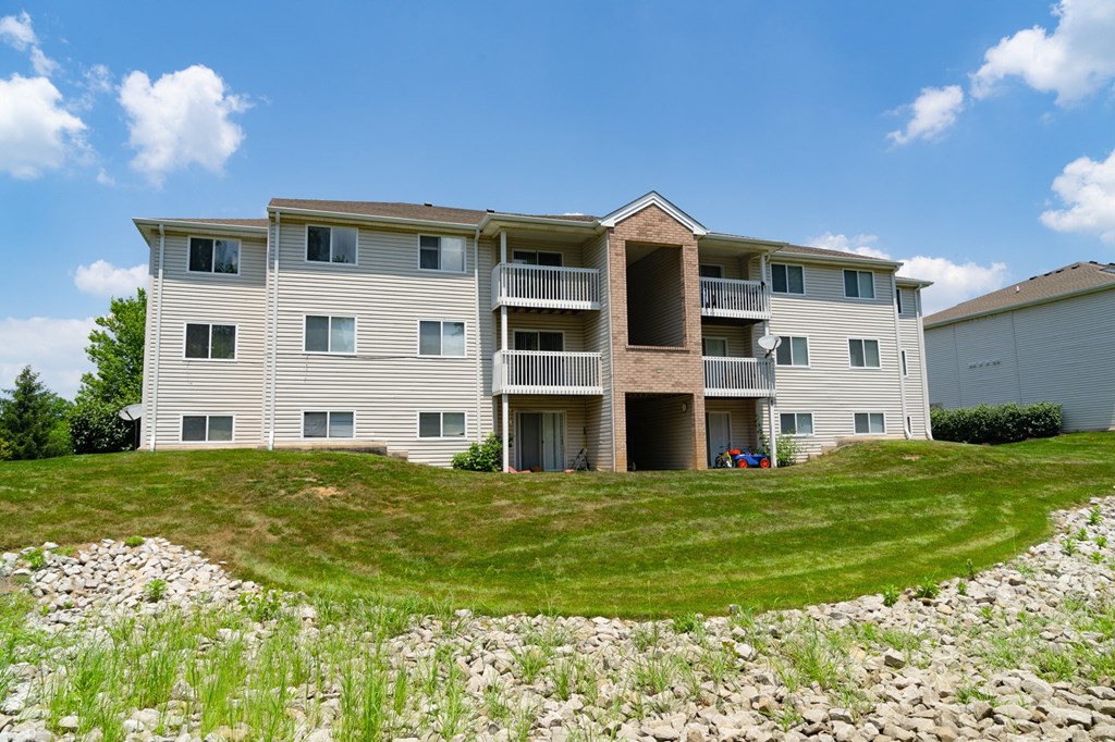 an apartment building on a hill with grass