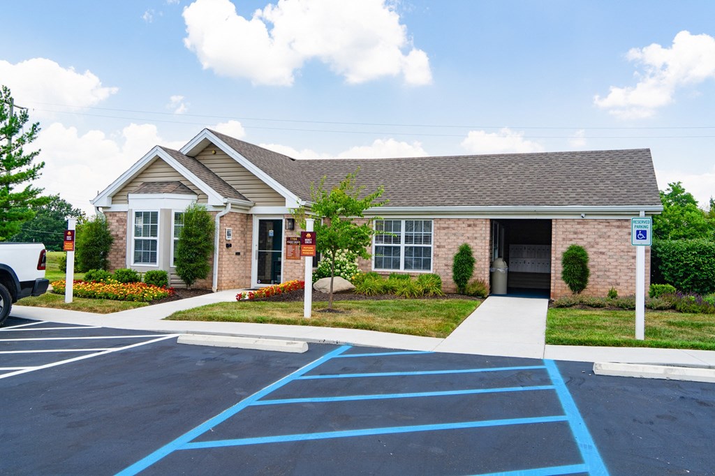 a brick house with a driveway and a parking lot