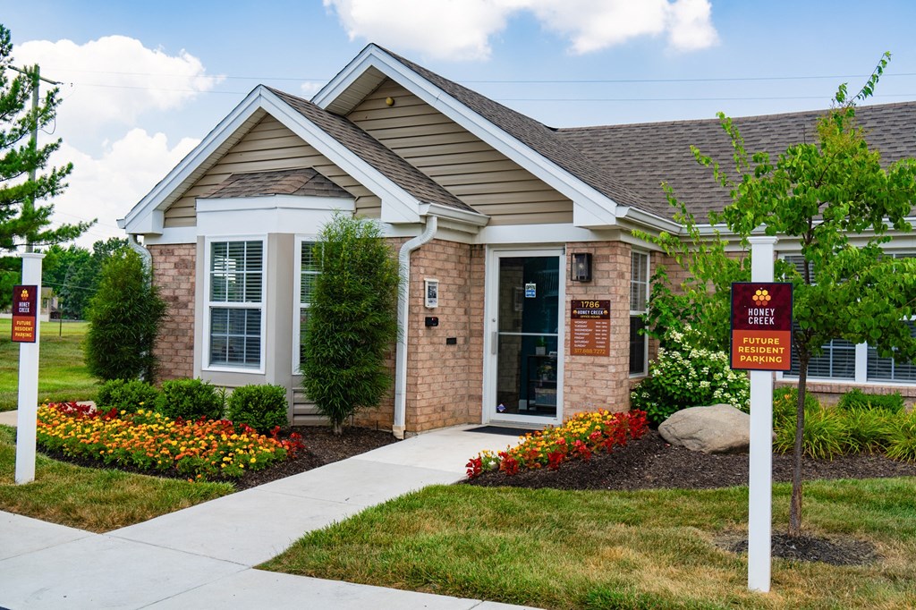 a brick house with a red sign in front of it