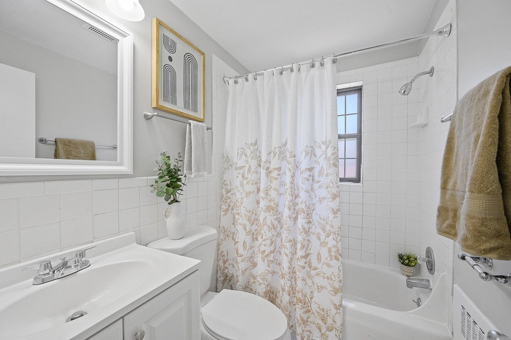 a bathroom with a shower curtain and a sink and a toilet