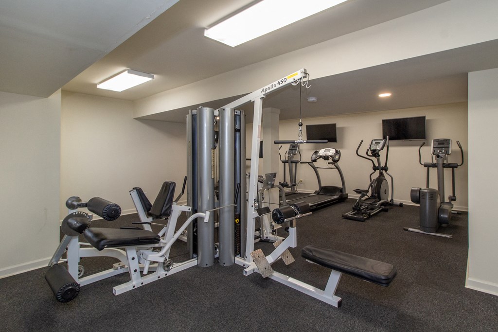 a gym with weights and cardio equipment on the floor and a tv at Rivers Edge Apartments and Townhomes, Ohio, 45405