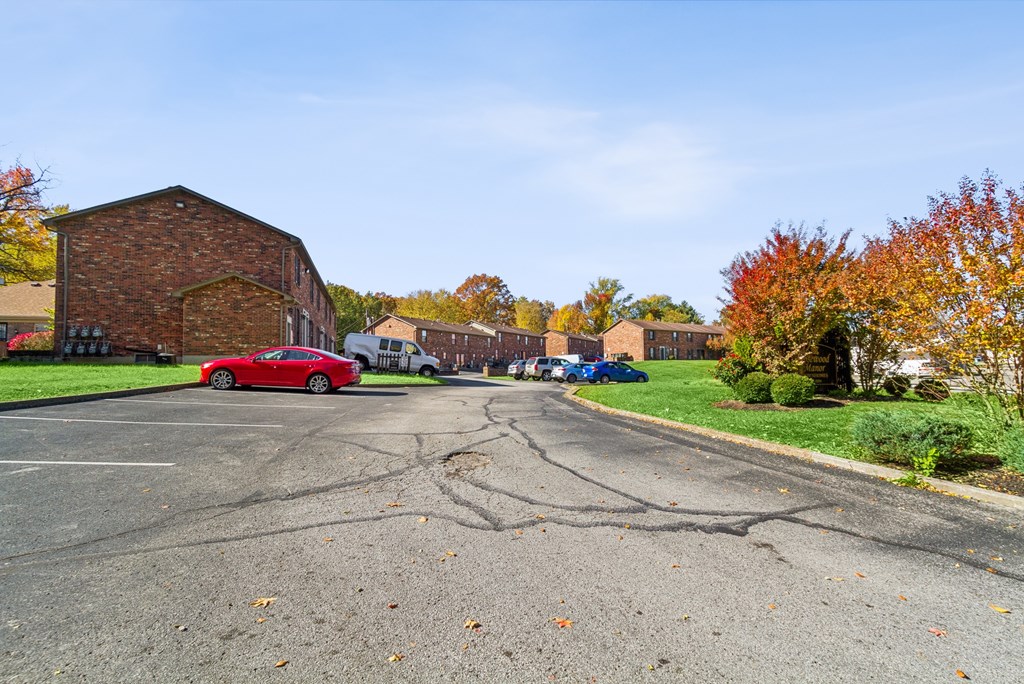 A red car is parked on the left side of a street.