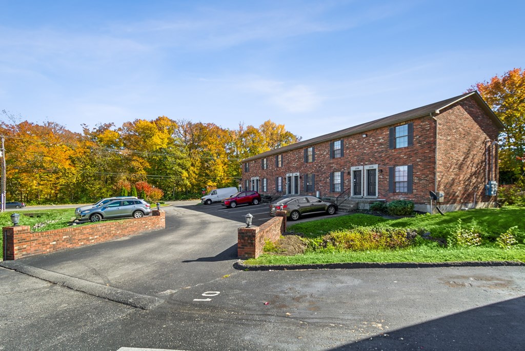 A red brick house with a driveway in front.
