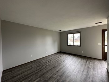 an empty living room with gray walls and a window - Photo Gallery 19