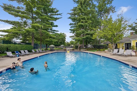 A group of people are swimming in a blue pool.