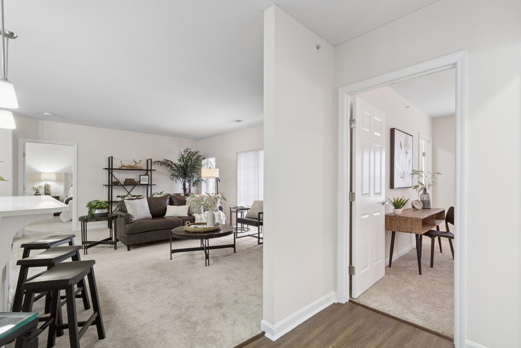 A living room with a couch, chairs, and a dining table.