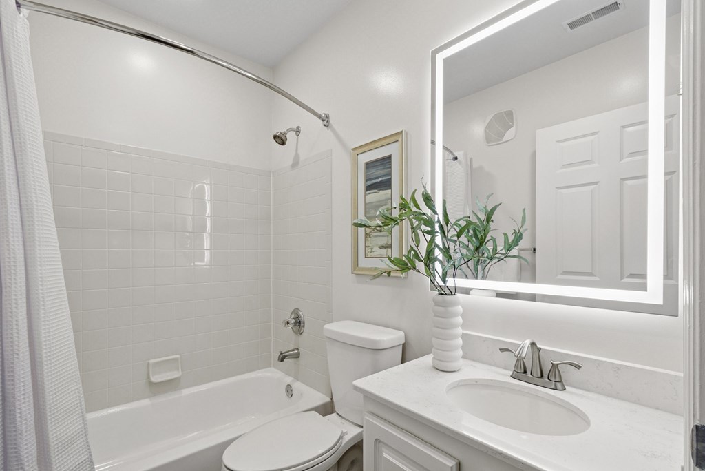 A white bathroom with a toilet, sink, and tub.