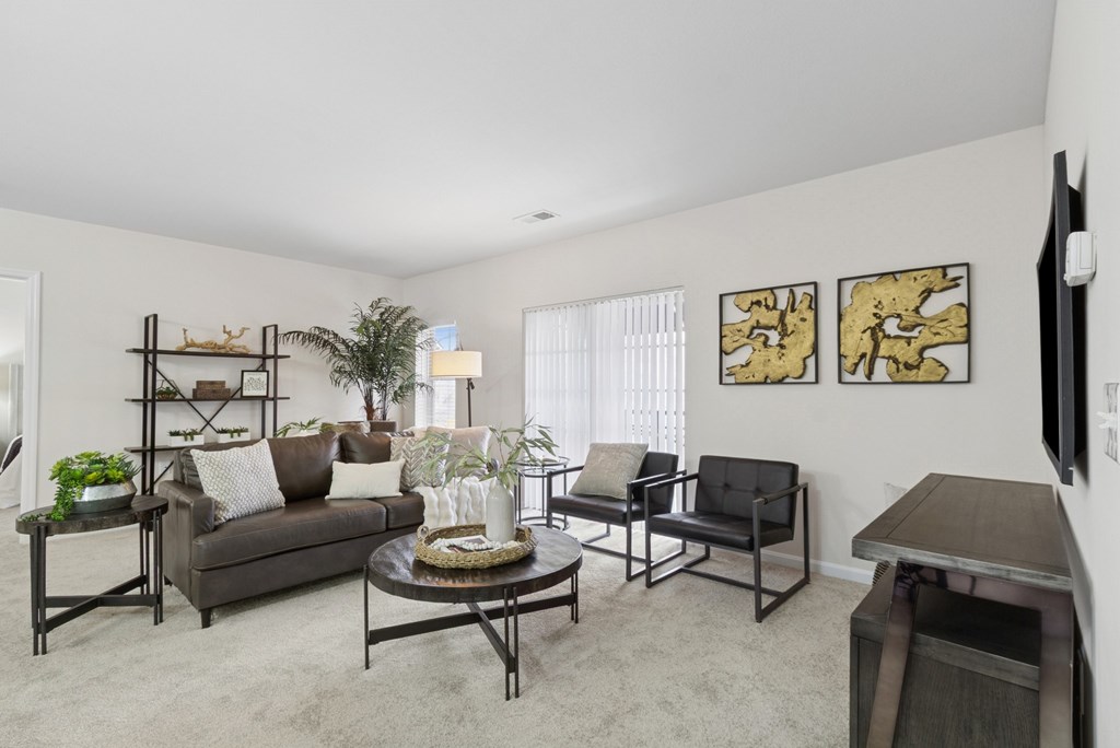 A living room with a couch, chairs, and a coffee table.