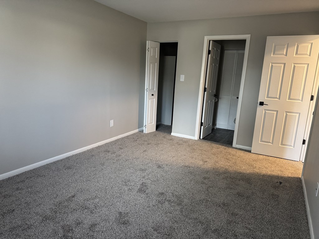 A room with grey carpet at Quail Run Apartments, Columbus, IN