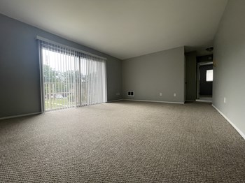 an empty living room with a sliding glass door - Photo Gallery 27