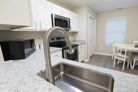 A kitchen with a sink and a microwave.
