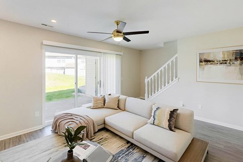 A living room with a white couch and a ceiling fan.