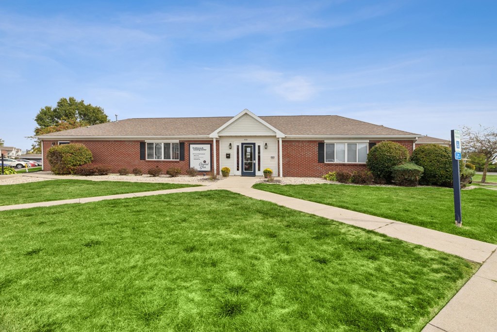A small brick building with a white sign on the front door.