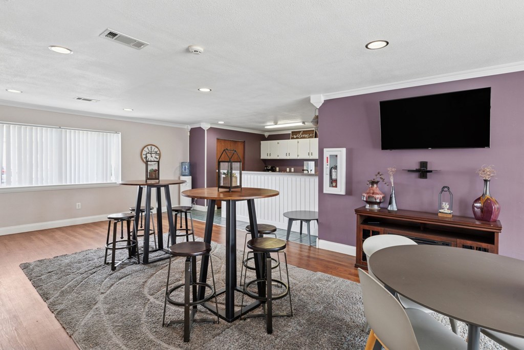 A room with a purple wall and a black television mounted on it.