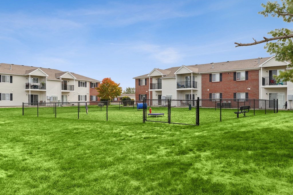 A grassy area in front of apartment buildings.