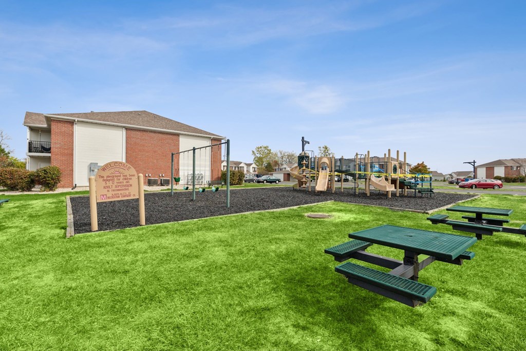 Picnic tables are set up on a green lawn.