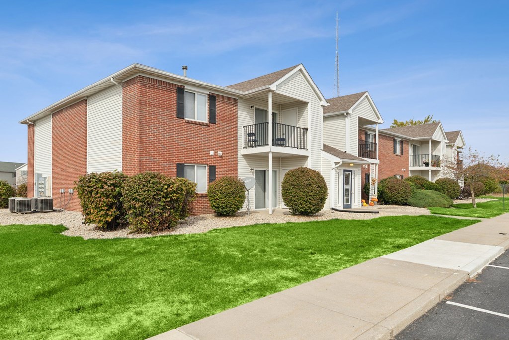 A row of houses with green lawns in front.