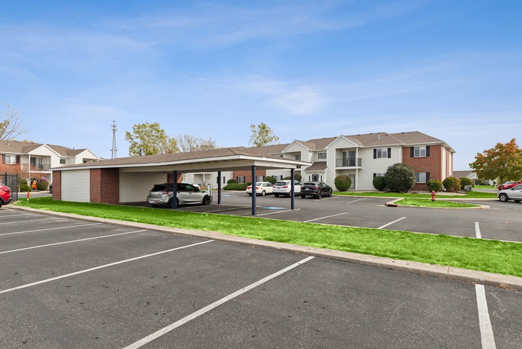 A parking lot with cars and a building in the background.