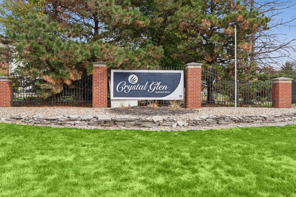 A sign that says Crystal Glen stands in front of a gate.