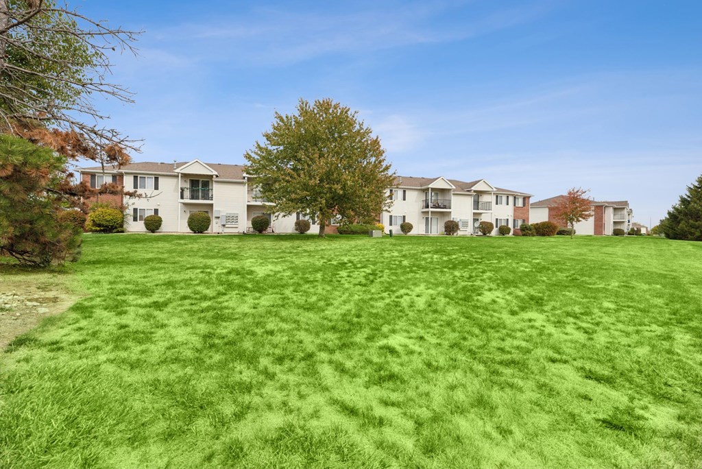 A row of houses with a green lawn in front.