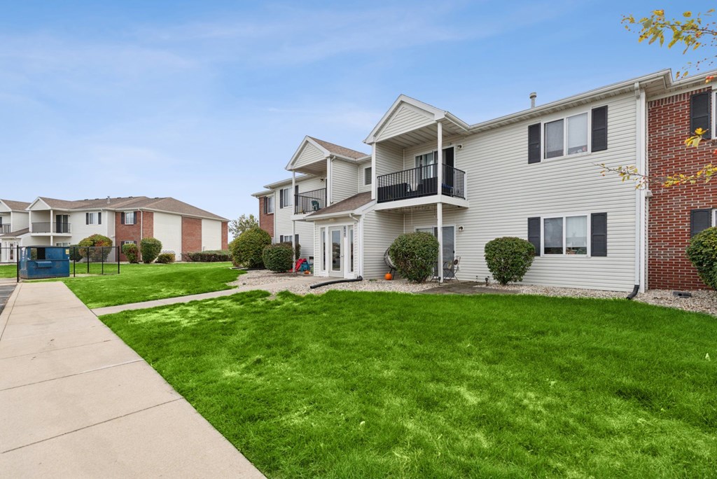 A row of houses with a green lawn in front.